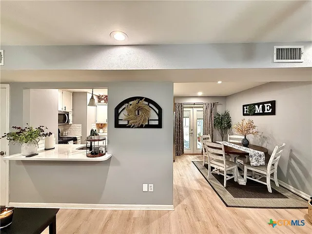 a living room with dining room and wooden floor