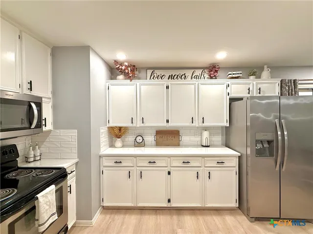 a kitchen with cabinets and stainless steel appliances