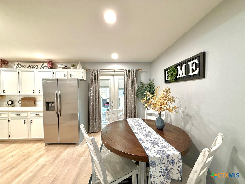 213 Sparrow Lane Victoria, TX 77905 - Photo 21 of 44 a kitchen with stainless steel appliances kitchen island granite countertop a refrigerator a stove a sink dishwasher with a dining table and chairs