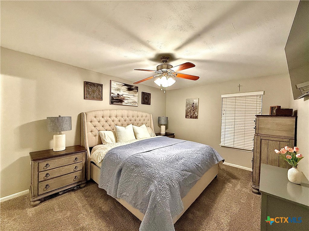 213 Sparrow Lane Victoria, TX 77905 - Photo 24 of 44 a spacious bedroom with a bed and a chandelier
