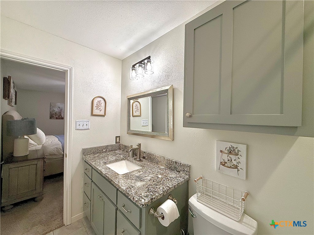 213 Sparrow Lane Victoria, TX 77905 - Photo 27 of 44 a bathroom with a granite countertop sink and a mirror