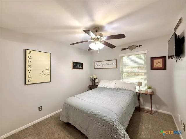 a bedroom with a bed and a flat tv screen on dresser