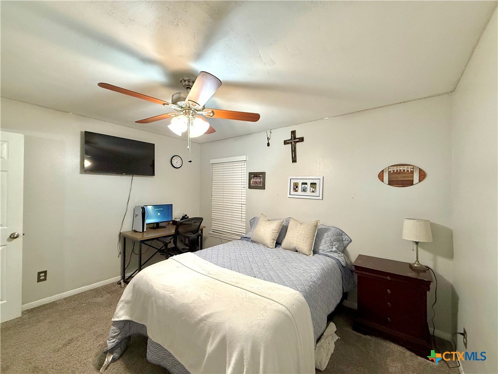 213 Sparrow Lane Victoria, TX 77905 - Photo 32 of 44 a bedroom with a bed and a flat tv screen on dresser
