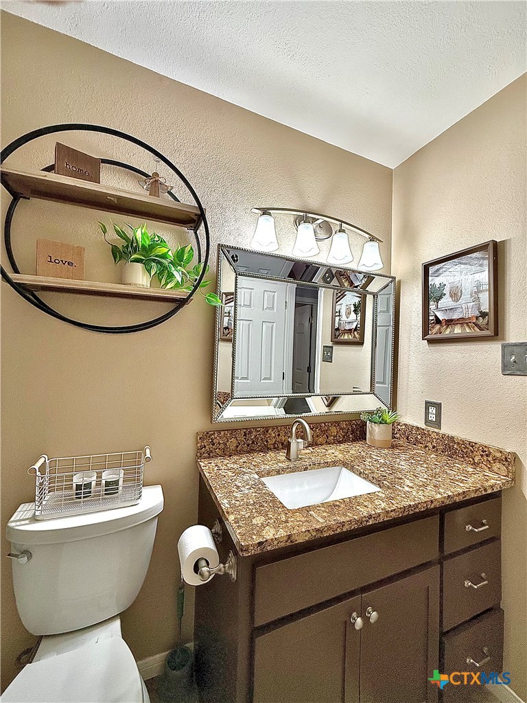 213 Sparrow Lane Victoria, TX 77905 - Photo 35 of 44 a bathroom with a granite countertop toilet a sink and a mirror