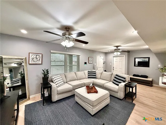 a living room with furniture and a wooden floor