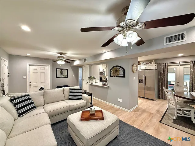 a living room with furniture and a wooden floor