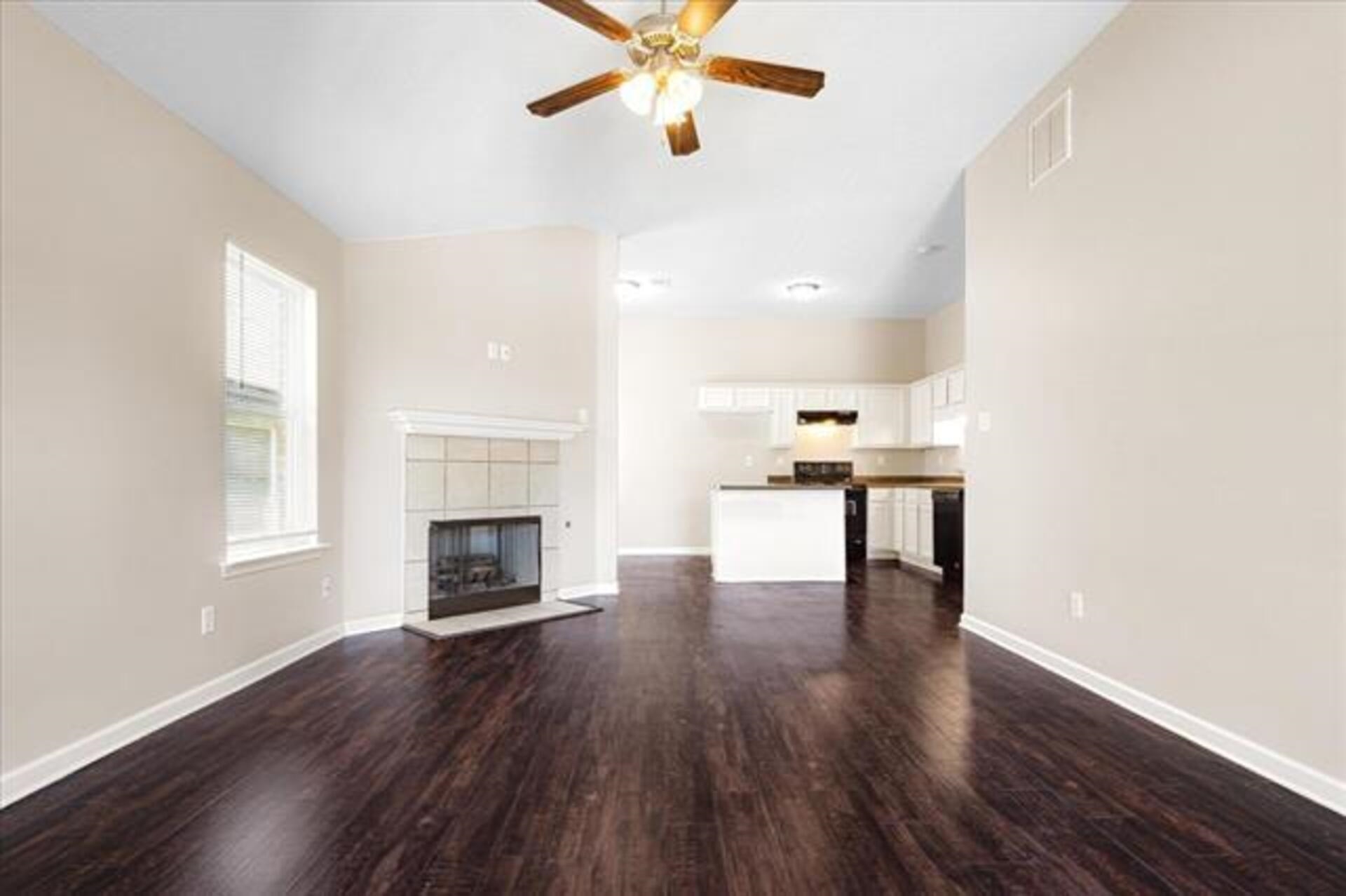 5569 Falling Bark Drive Memphis, TN 38134 - Photo 11 of 31 an empty room with wooden floor fireplace and windows