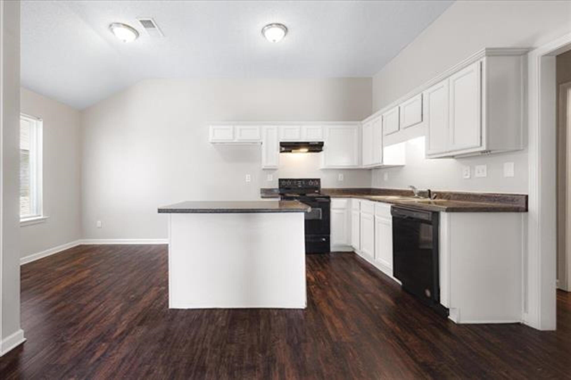 5569 Falling Bark Drive Memphis, TN 38134 - Photo 14 of 31 a kitchen with granite countertop wooden floors and white stainless steel appliances