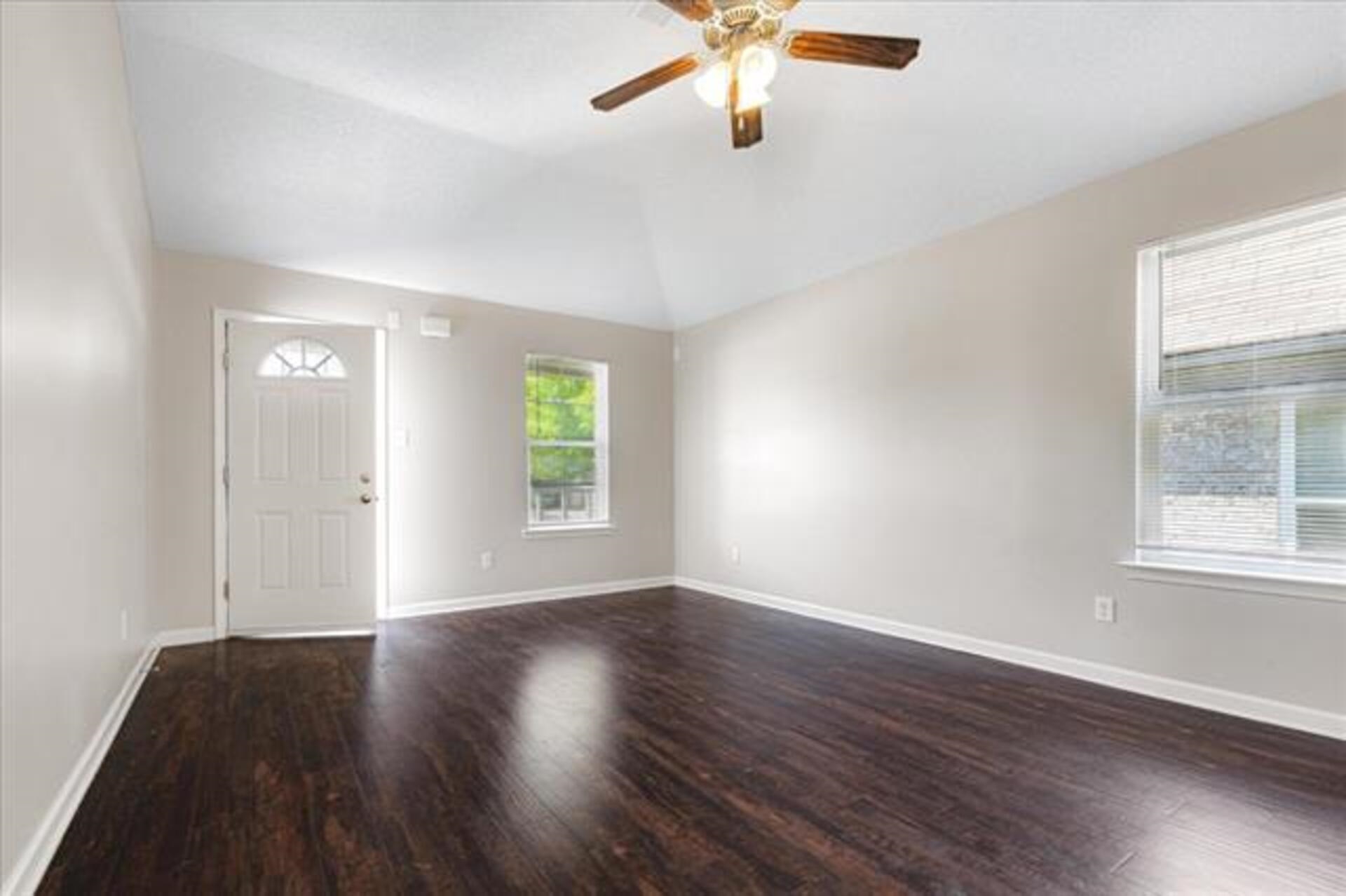 5569 Falling Bark Drive Memphis, TN 38134 - Photo 7 of 31 an empty room with wooden floor chandelier fan and windows