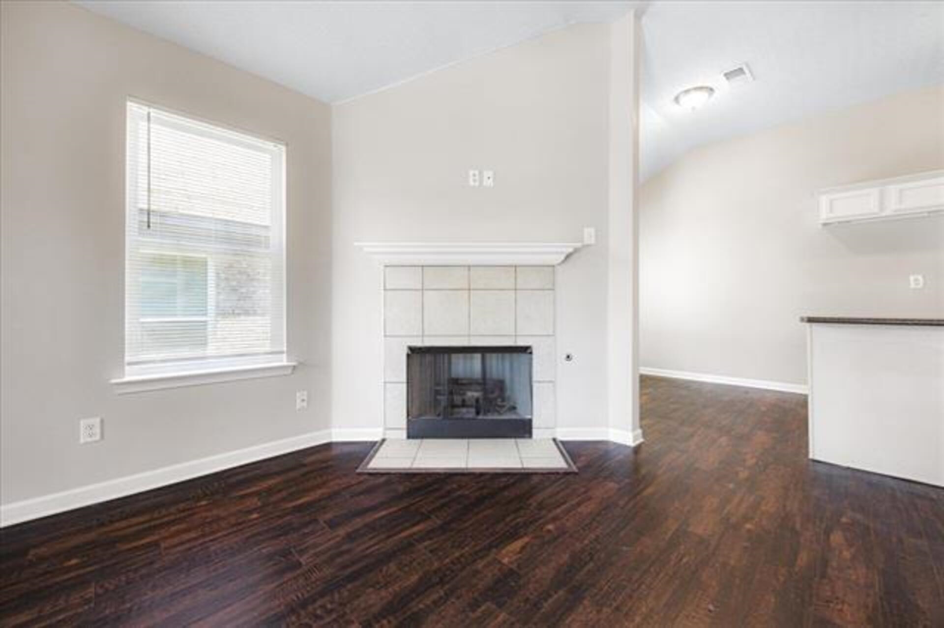 5569 Falling Bark Drive Memphis, TN 38134 - Photo 9 of 31 an empty room with wooden floor fireplace and windows