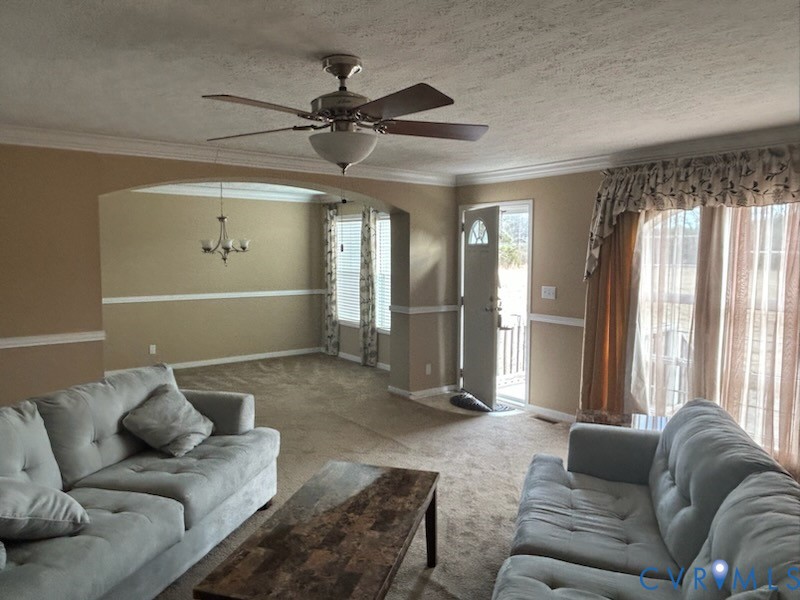 15910 Nobles Road Disputanta, VA 23842 - Photo 16 of 38 Carpeted living room with a textured ceiling, arch
