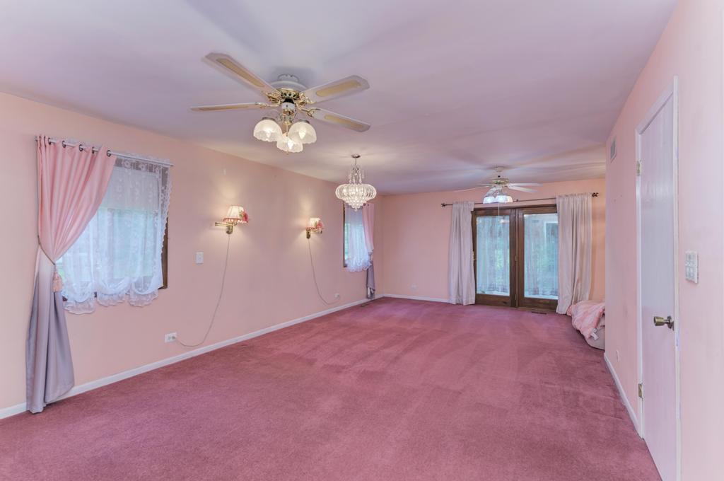 457 Fall Circle Roselle, IL 60172 - Photo 11 of 37 a view of a big room with chandelier fan and windows