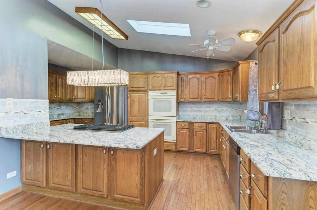 457 Fall Circle Roselle, IL 60172 - Photo 21 of 37 a kitchen with granite countertop a sink a counter space appliances and cabinets