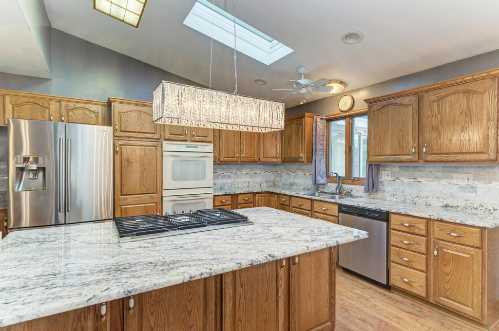 457 Fall Circle Roselle, IL 60172 - Photo 22 of 37 a kitchen with stainless steel appliances granite countertop a sink window and cabinets