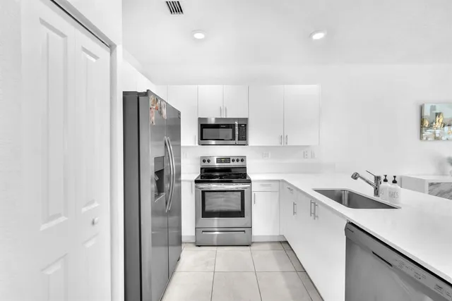 a kitchen with a sink cabinets and stainless steel appliances