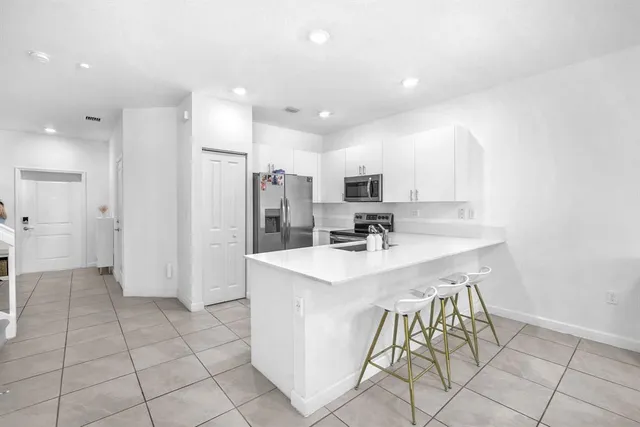 a kitchen with stainless steel appliances a sink a refrigerator and a stove top oven