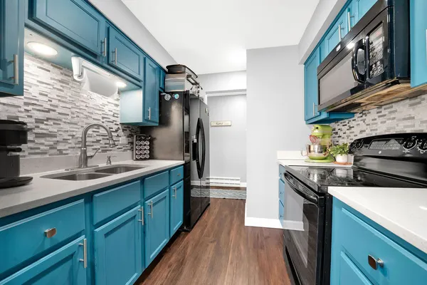 a kitchen with stainless steel appliances granite countertop a sink a stove and cabinets