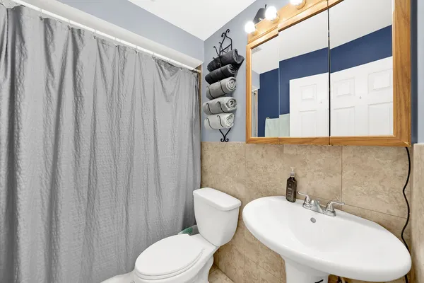a bathroom with a sink a toilet and a mirror
