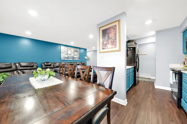 a view of a dining room with furniture a potted plant and wooden floor