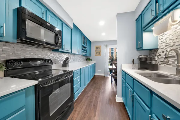 a kitchen with stainless steel appliances a stove sink microwave and cabinets