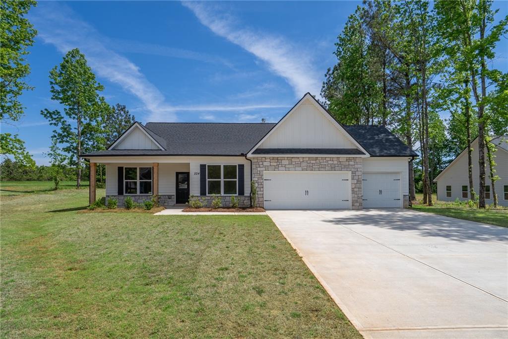 a front view of a house with a yard and trees