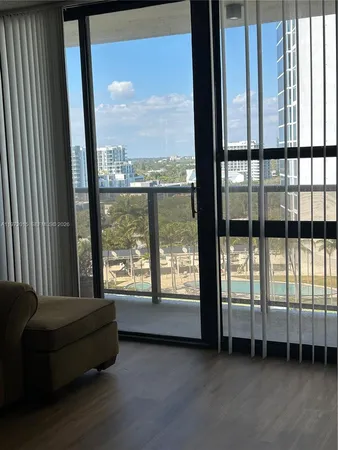 a spacious bedroom with a large window and a balcony