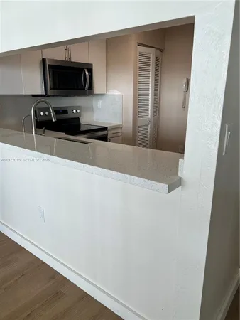a kitchen with a refrigerator and a stove top oven