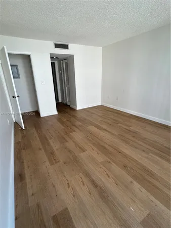 an empty room with wooden floor and closet