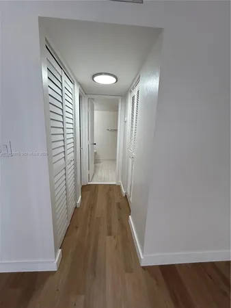 a view of hallway with stairs and wooden floor