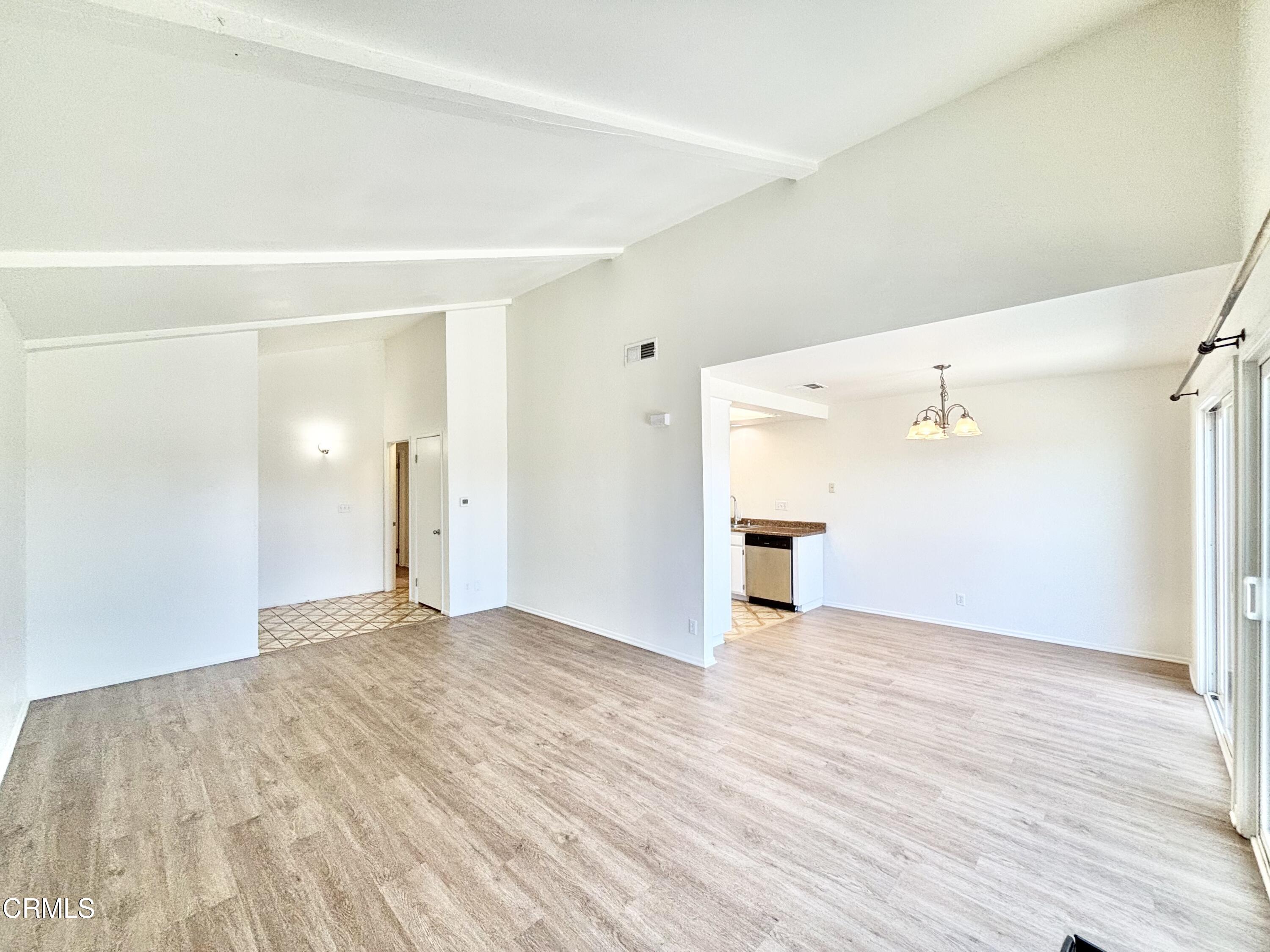a view of a big room with wooden floor and windows