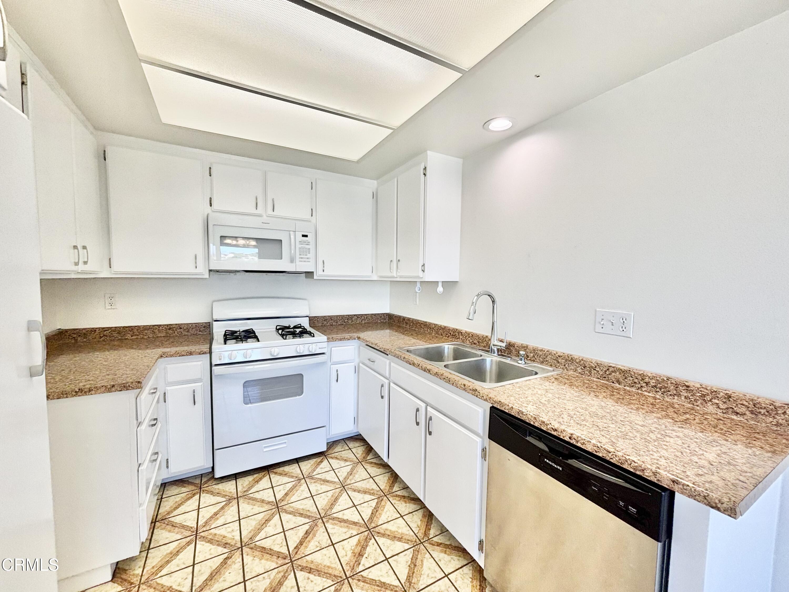 4911 Catamaran Street Oxnard, CA 93035 - Photo 20 of 38 a kitchen with stainless steel appliances granite countertop a sink stove and cabinets