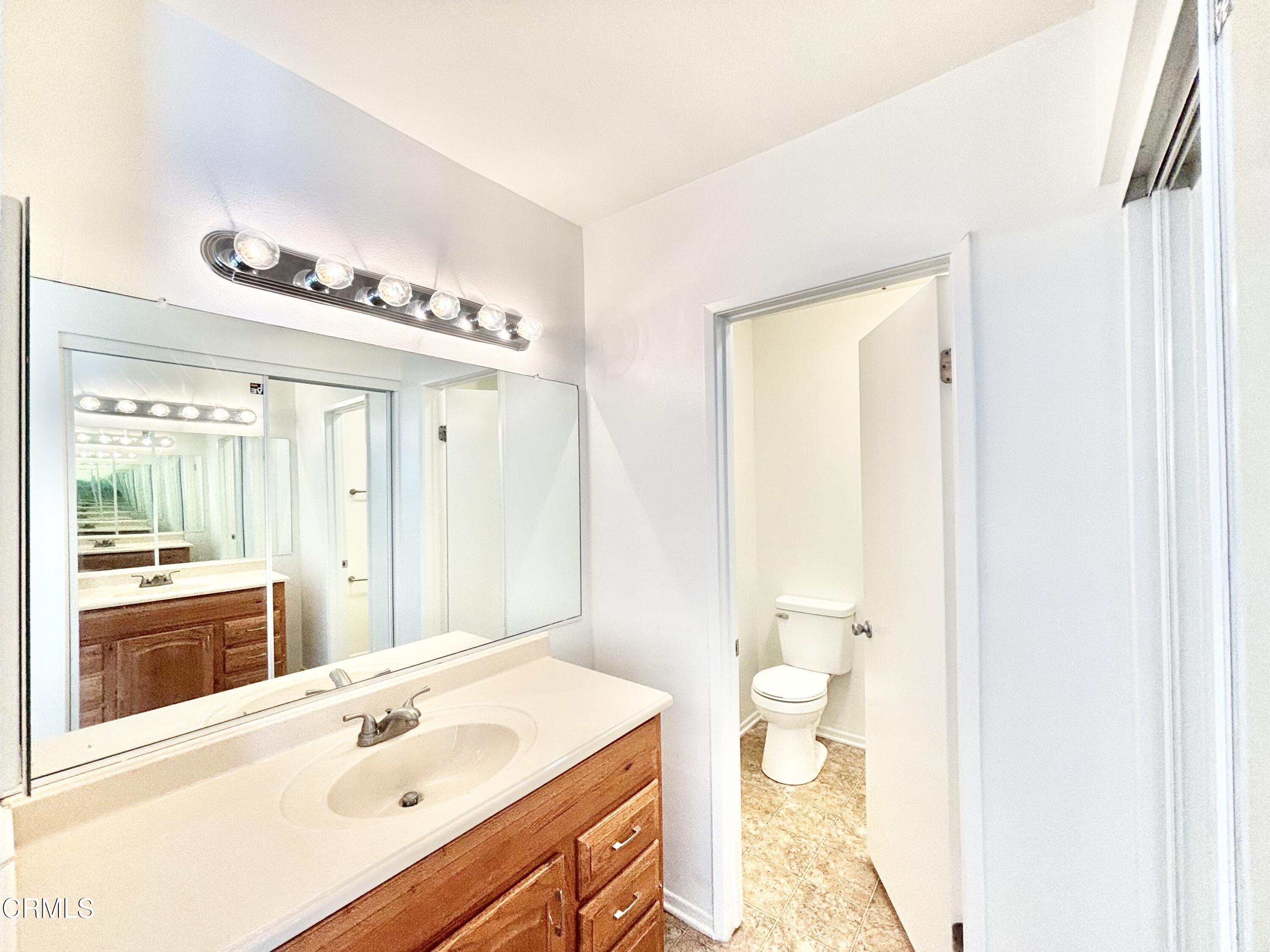 4911 Catamaran Street Oxnard, CA 93035 - Photo 24 of 38 a bathroom with a sink mirror and a toilet