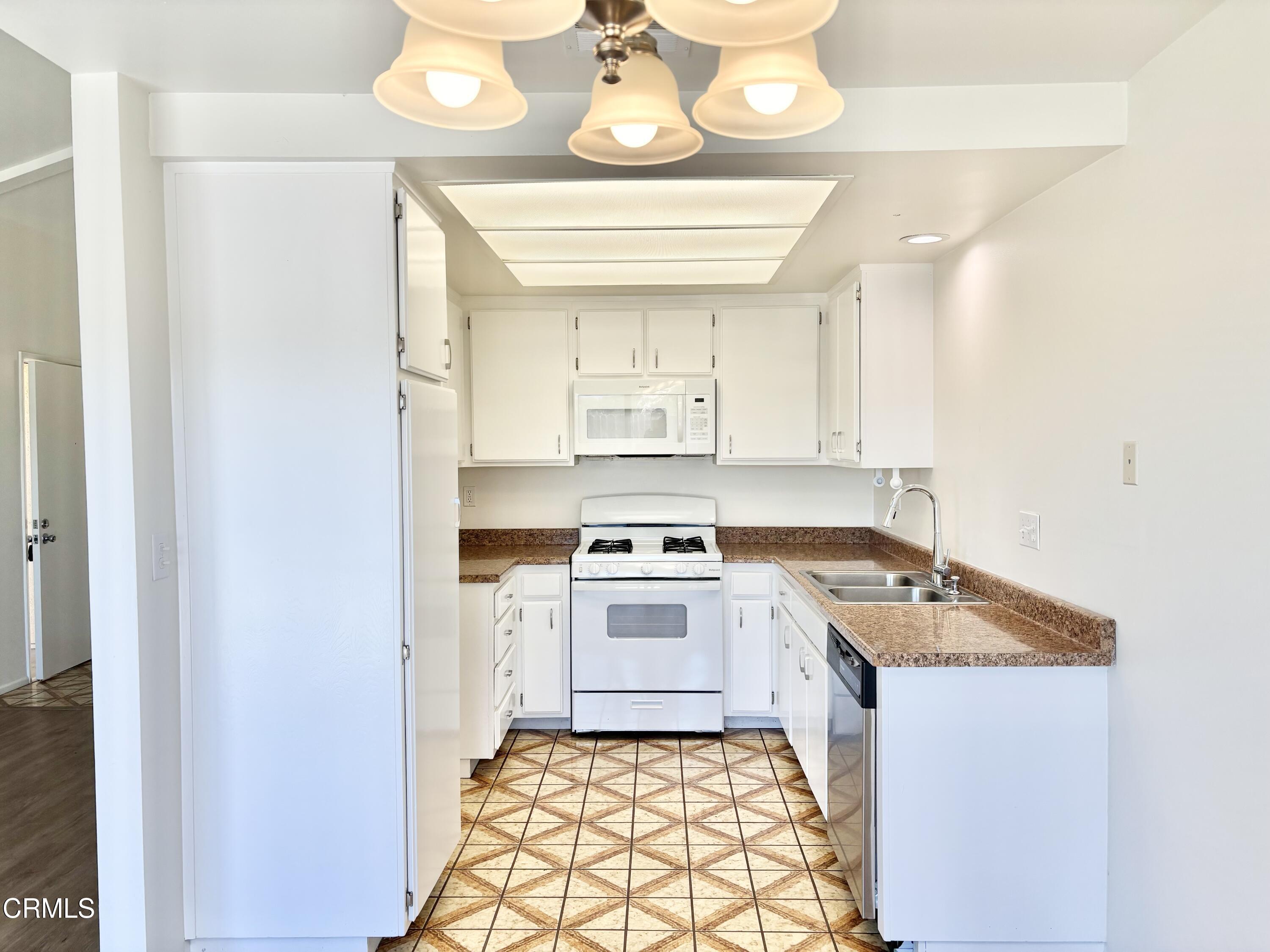 4911 Catamaran Street Oxnard, CA 93035 - Photo 6 of 38 a kitchen with a stove a sink and a refrigerator