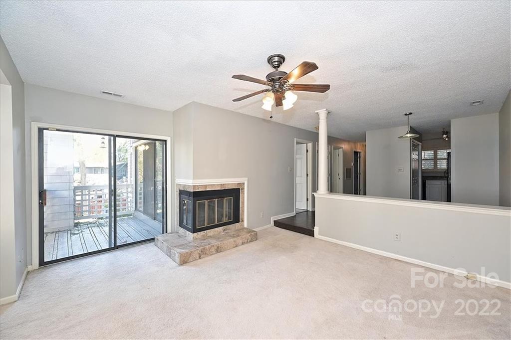 222 Queens Road, Unit 56 Charlotte, NC 28204 - Photo 11 of 23 a view of an empty room with a fireplace and a fan