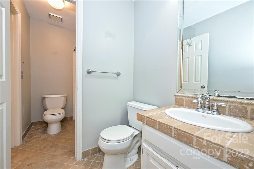 222 Queens Road, Unit 56 Charlotte, NC 28204 - Photo 17 of 23 a bathroom with a sink toilet and mirror