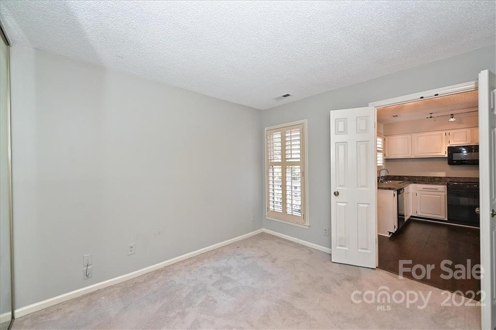 222 Queens Road, Unit 56 Charlotte, NC 28204 - Photo 20 of 23 an empty room with windows and cabinet