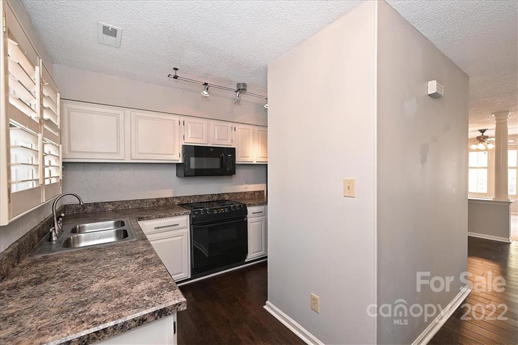 222 Queens Road, Unit 56 Charlotte, NC 28204 - Photo 3 of 23 a kitchen with stainless steel appliances granite countertop a sink stove and microwave