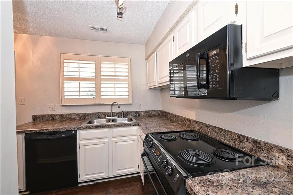 222 Queens Road, Unit 56 Charlotte, NC 28204 - Photo 4 of 23 a kitchen that has a sink a stove and a microwave