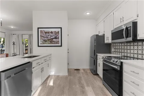 a kitchen with stainless steel appliances a stove microwave and refrigerator
