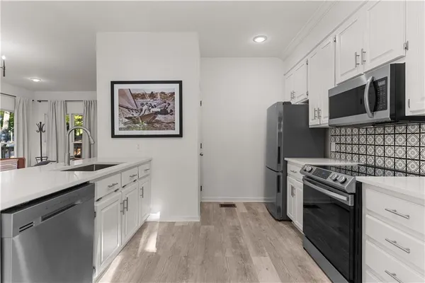a kitchen with stainless steel appliances a stove microwave and refrigerator