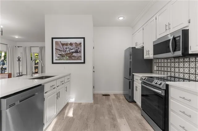 a kitchen with stainless steel appliances a stove microwave and refrigerator