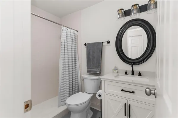 a bathroom with a sink mirror vanity and toilet