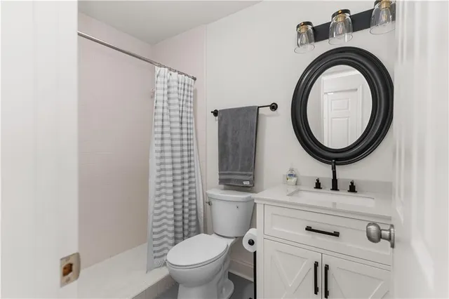 a bathroom with a sink mirror vanity and toilet