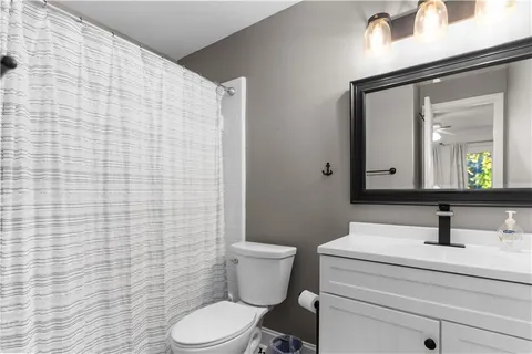 a bathroom with a sink a toilet and mirror