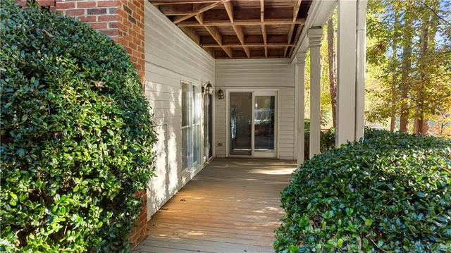 a view of a porch with wooden floor and potted plants