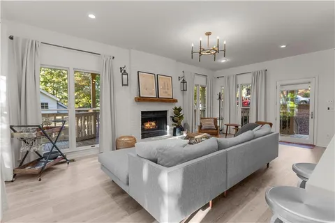 a living room with furniture a fireplace and a chandelier
