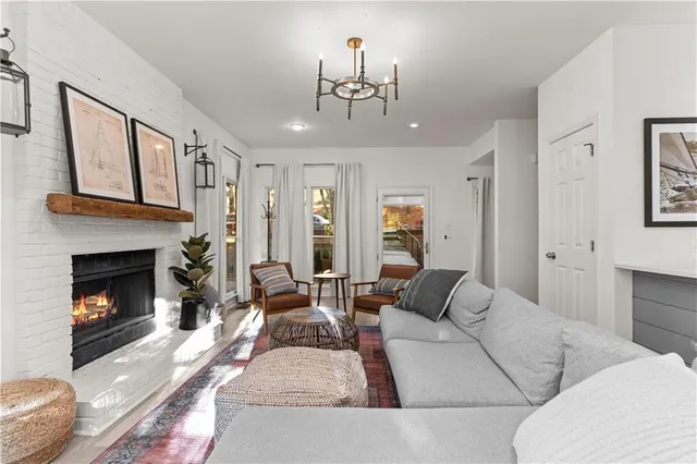 a living room with furniture a chandelier and a fireplace