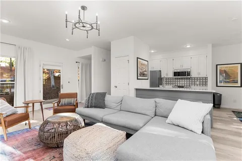 a living room with furniture and a large mirror with wooden floor