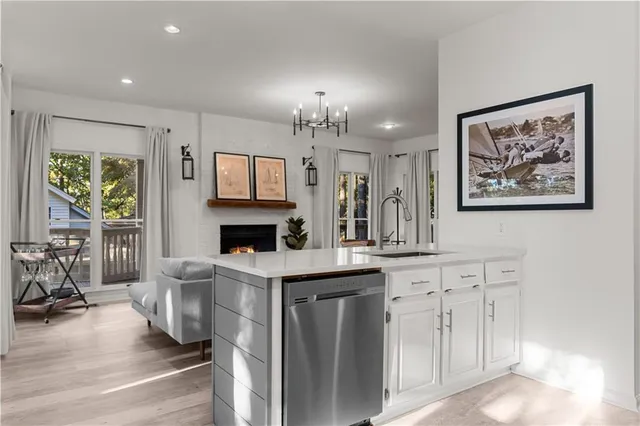 a view of a kitchen with granite countertop a fireplace cabinets and a dining table