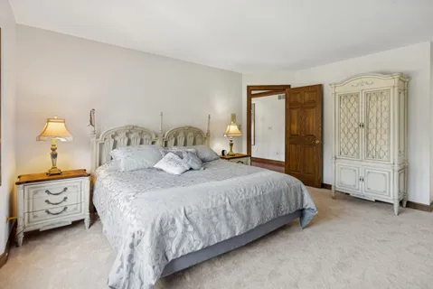 a bedroom with a bed a mirror and lamp